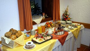 A buffet table with various food items, including bread, fruits, and a dessert. - Pension St. Georg Mit Moststüberl (Bad Griesbach im Rottal)