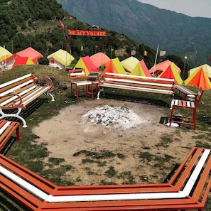 A campsite with colorful tents, wooden benches, and a sign reading "The Sky Village". - The Sky Village (Baijnath)