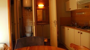 Une cuisine de taille réduite, avec des meubles en bois, un évier et une cuisinière.