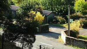 Un lotissement résidentiel fermé, doté d’une route asphaltée, d’un mur en pierre et d’une végétation luxuriante.