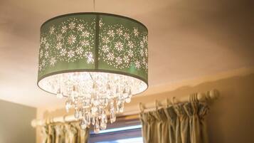 Un candelabro con pantalla verde y motivos florales.