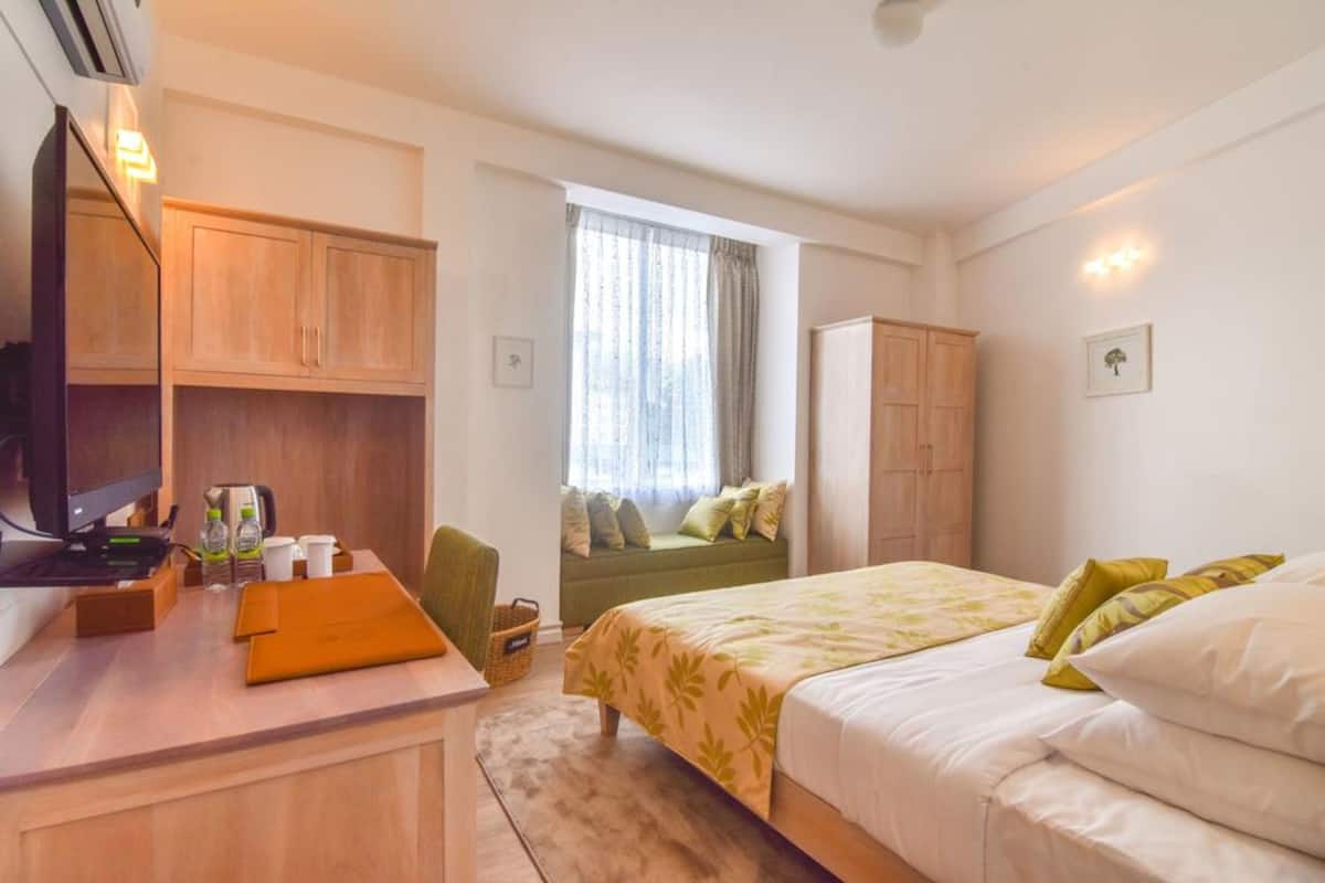 Deluxe Room, Garden View | Minibar, in-room safe, desk, blackout curtains