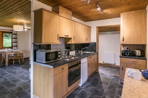 Una cocina moderna con armarios de madera, microondas, estufa y lavavajillas.