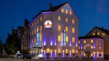 Ein mehrstöckiges Hotelgebäude mit beleuchteter Beschilderung und zahlreichen Fenstern.