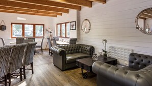 A cozy room with a leather sofa, patterned chairs, a wooden table, and a mirror on the wall. - Roydon Marina Village Hotel (Harlow)