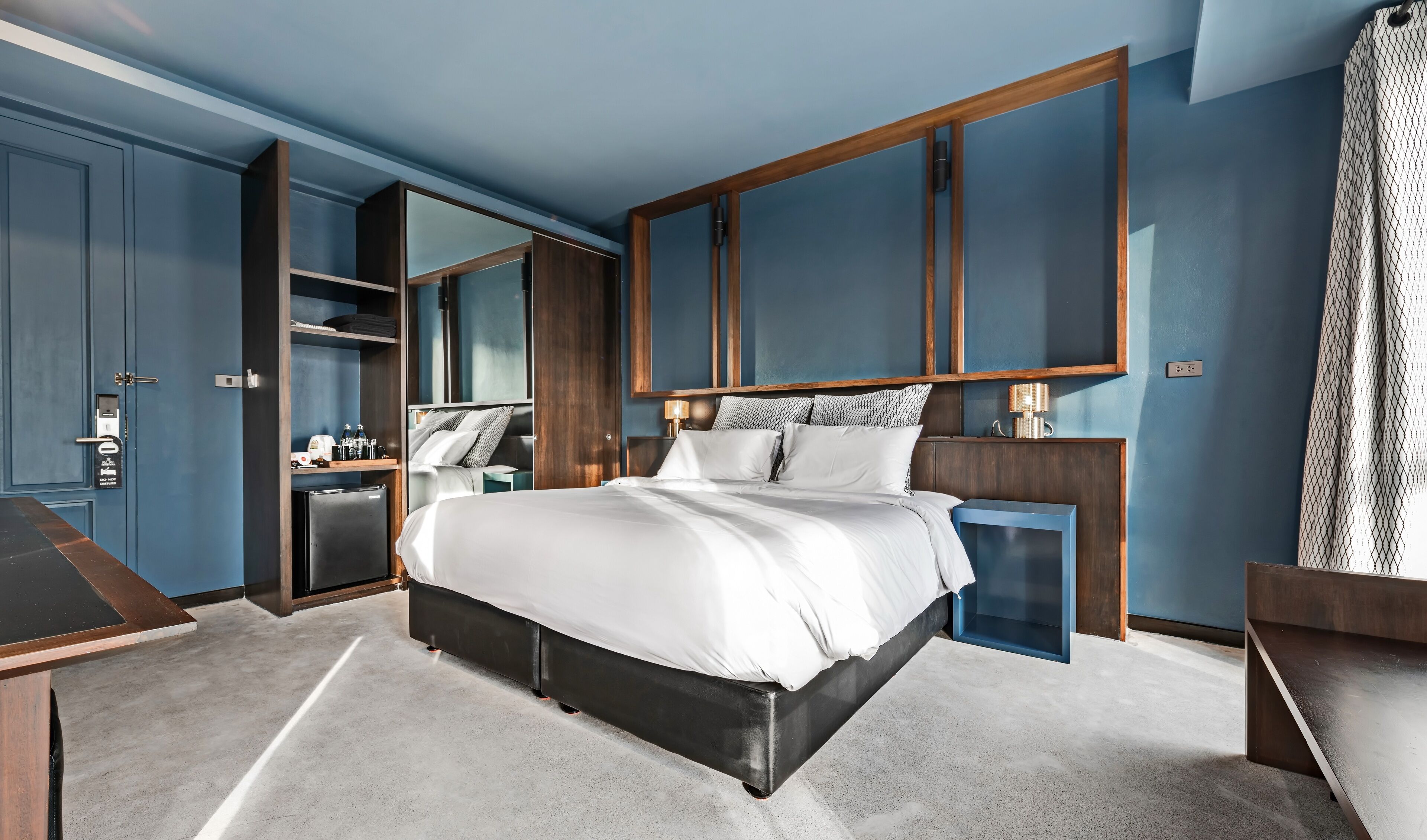 Ein modernes Schlafzimmer mit einem großen Bett, einem Einbauschrank und einem Schreibtisch.