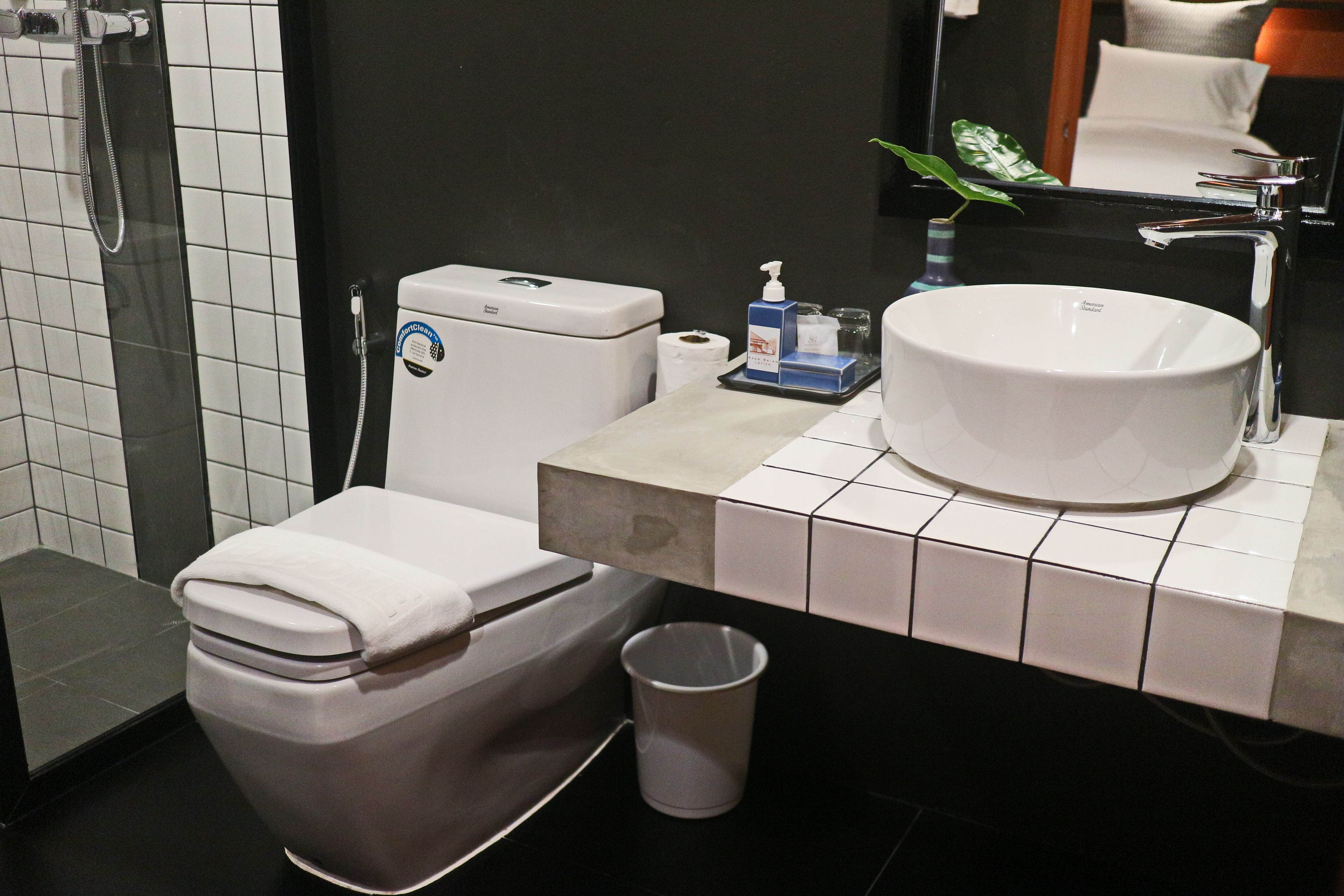 A modern bathroom with a white toilet, a sink, and a shower.