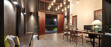A modern dining area with a patterned floor, wooden furniture, and pendant lighting.