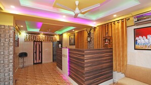 A reception area with a wooden reception desk, a ceiling fan, and a wall-mounted clock.