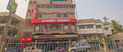 Un edificio de varios pisos con un llamativo letrero rojo que dice 'Kshounish Residency Hotel'.
