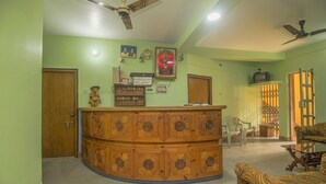A living room with a wooden cabinet, a sofa, a ceiling fan, and a television.