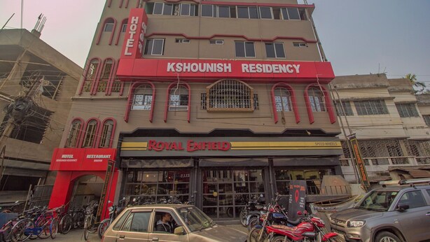 A building with a sign for 'Kshounish Residency Hotel' and 'Royal Enfield' below it.