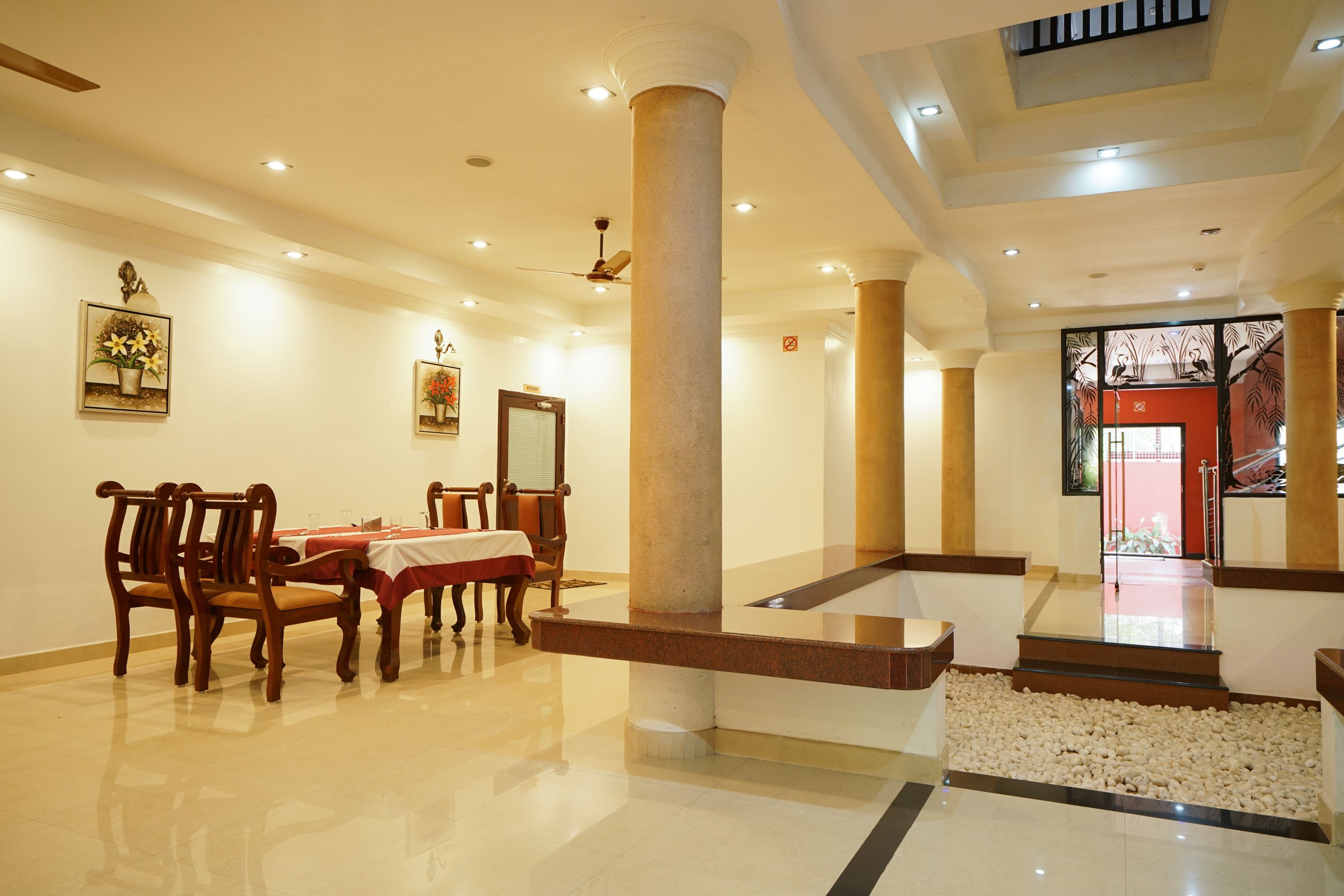 A spacious lobby with a polished floor, a reception desk, and a staircase leading to an upper level.