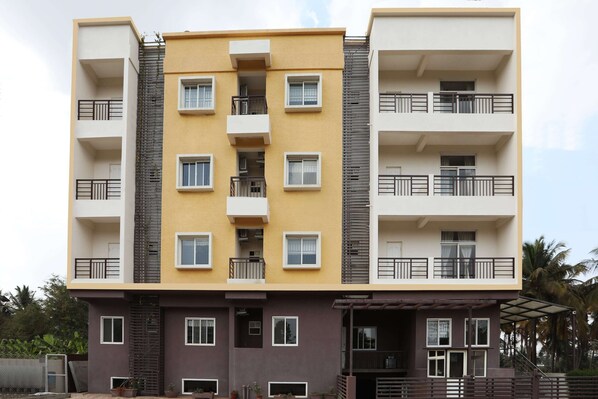 Um edifício residencial de vários andares com varandas, um núcleo central de escadas e um telhado plano.