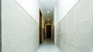 A narrow, tiled hallway with a wooden door at the end.