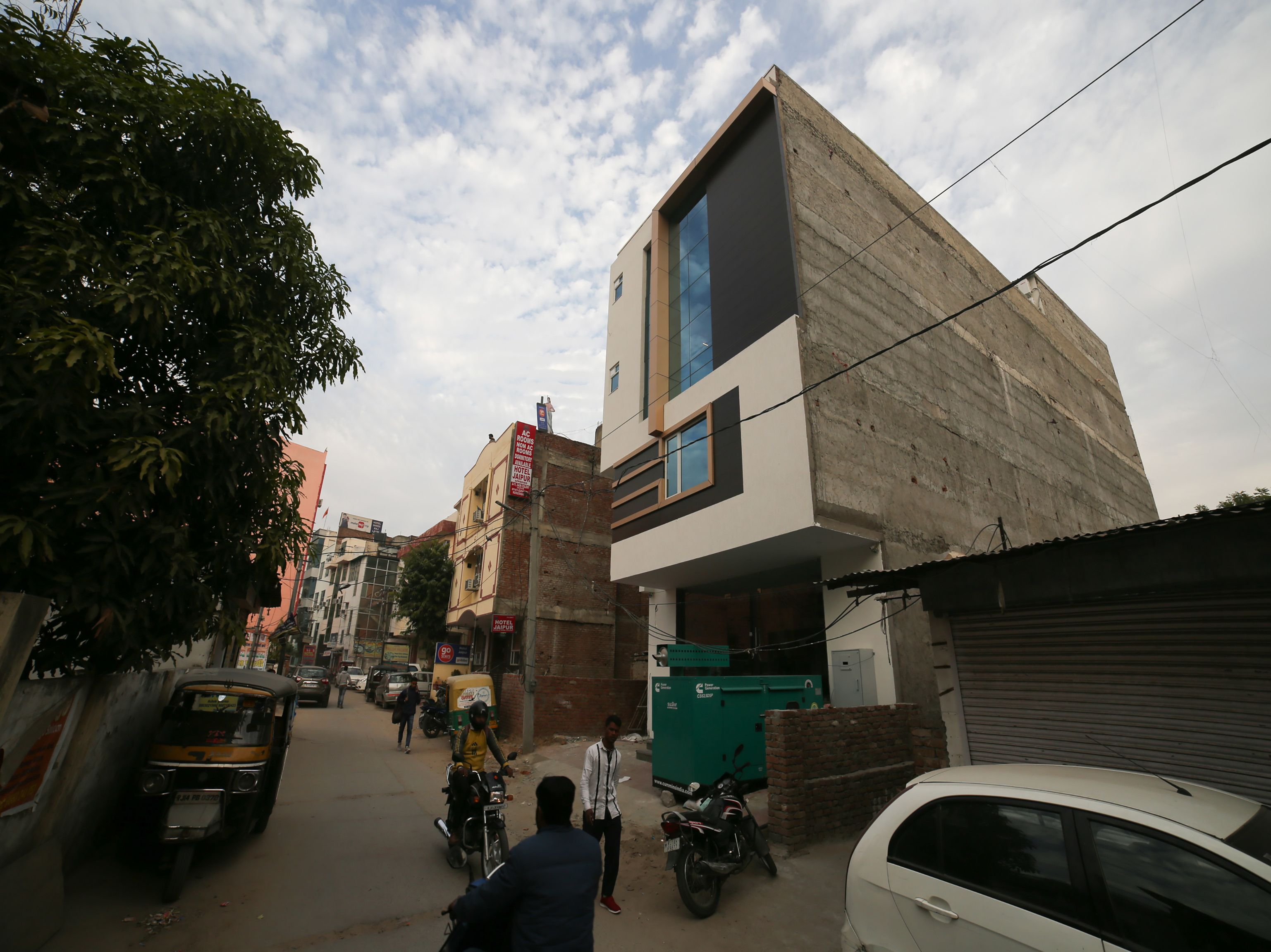 A modern building with a flat roof, large windows, and a visible sign for a hotel.