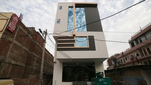 Un edifici modern amb teulada plana, grans finestres i una escala que condueix a l'entrada.