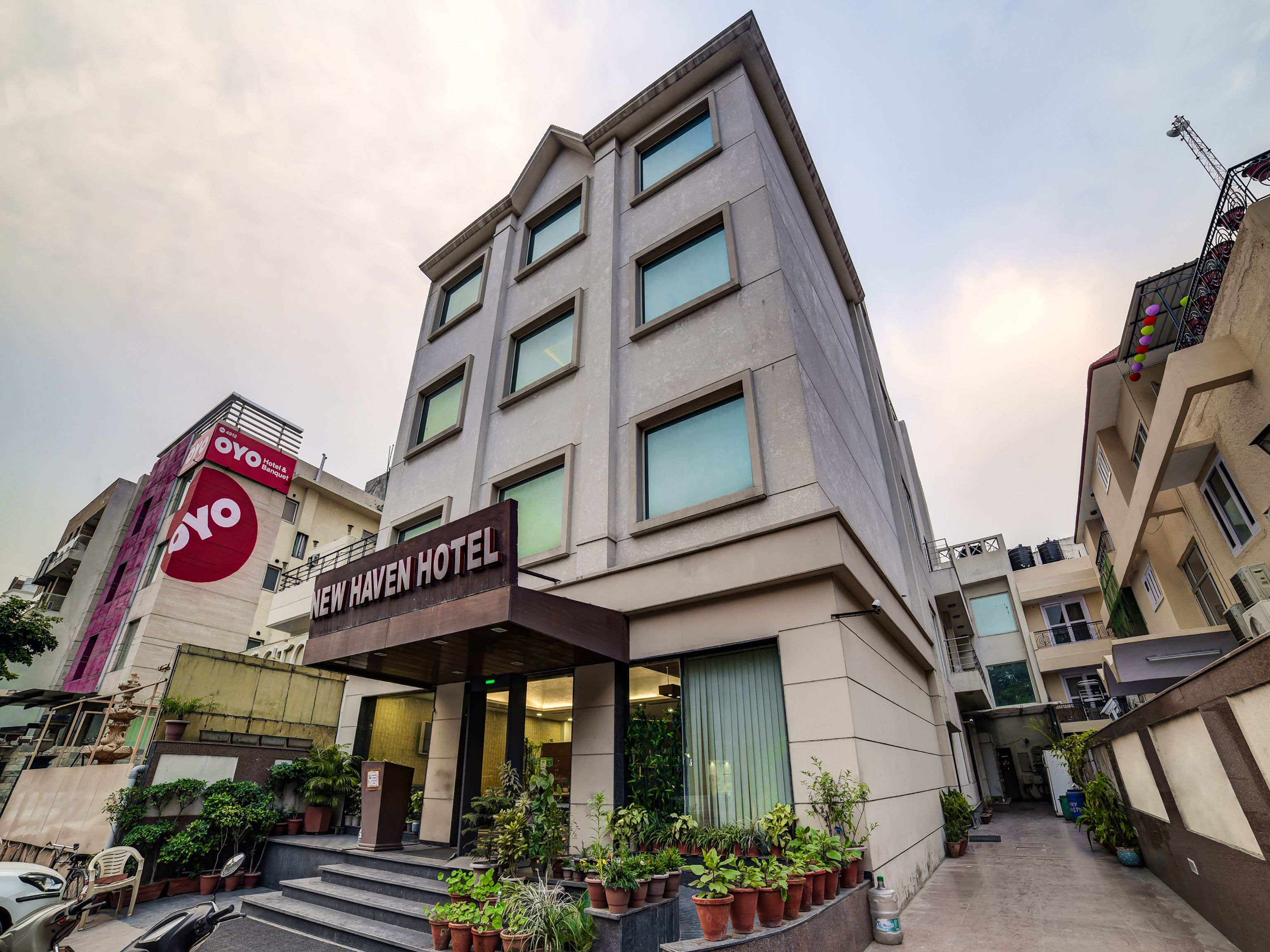 A multi-story hotel with a prominent sign for "New Haven Hotel" and a visible "Oyo Hotel & Banquet" sign.