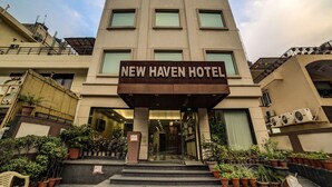 The exterior of the New Haven Hotel with a modern facade, multiple windows, and a prominent entrance. - Capital O 28618 New Haven Hotel (New Delhi)