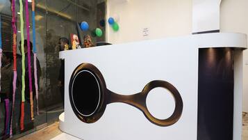 A reception desk with a modern design, featuring a circular handle and a black accent.