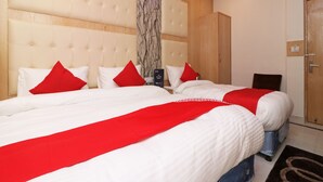 A hotel room with a large bed, two bedside tables, a wardrobe, and a marble accent wall. - OYO 13774 Check In Room (New Delhi)