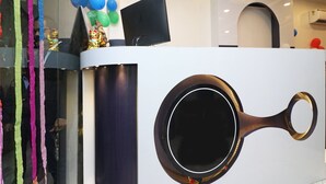A reception desk with a modern design, including a circular cut-out and a flat-screen TV. - OYO 13774 Check In Room (New Delhi)
