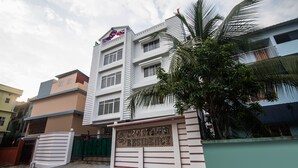 A multi-story building with a prominent entrance gate and a sign indicating it is a residence. - OYO 15700 Spectrum Residency (Guwahati)