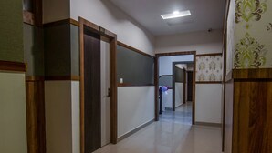 A hallway with a wooden door labeled '303', a tiled floor, and a patterned wall. - OYO 15700 Spectrum Residency (Guwahati)