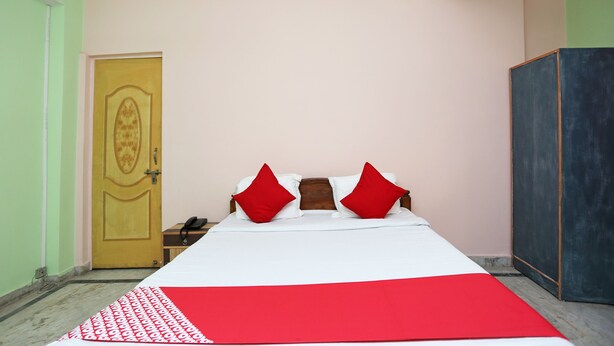 A room with a bed, a wardrobe, and a door.