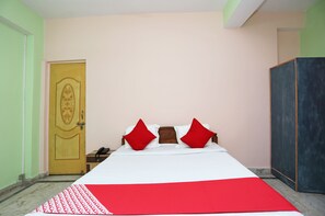 Een kamer met een bed, een kledingkast en een deur.