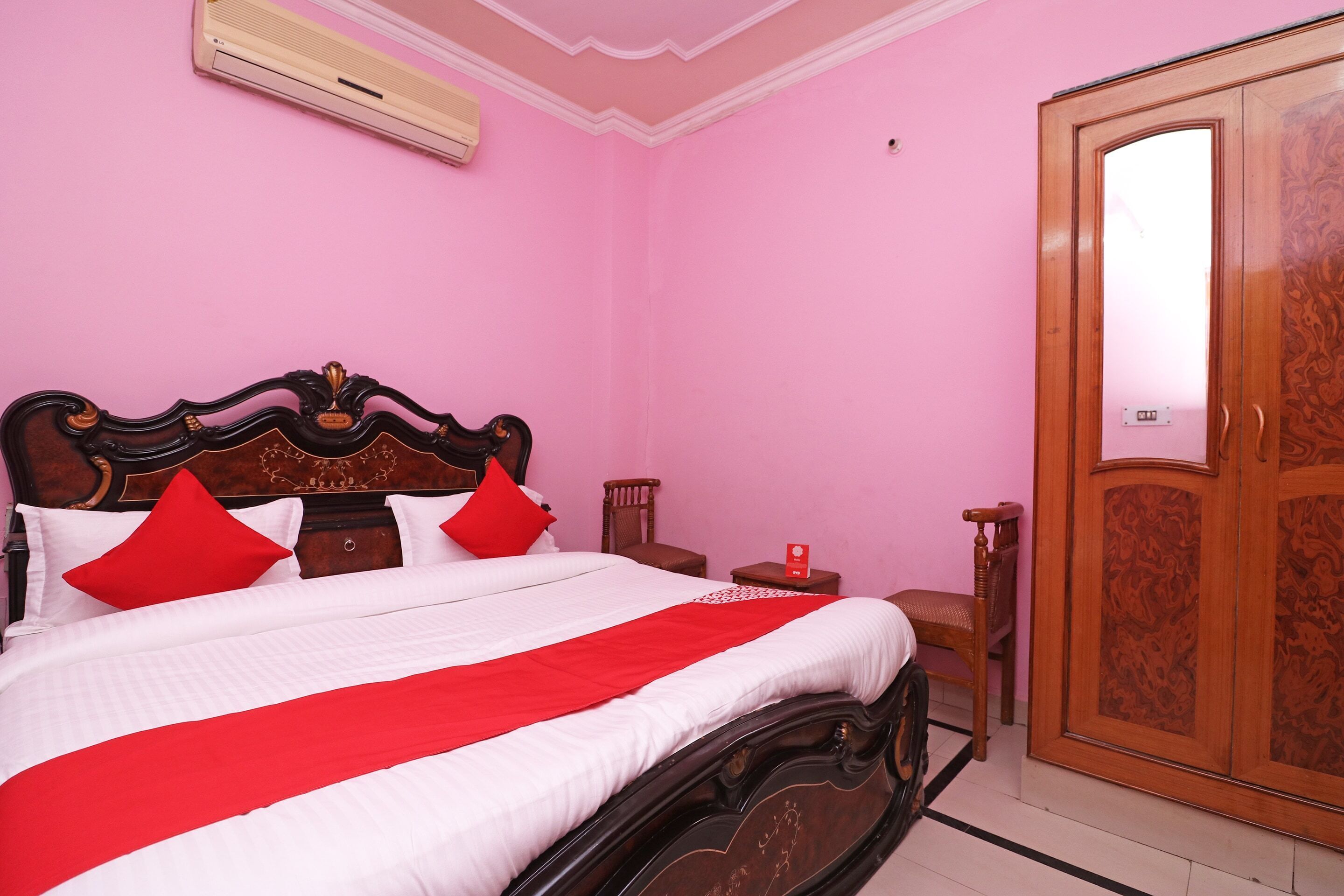 A bedroom with a large bed, a wardrobe, and a small table.