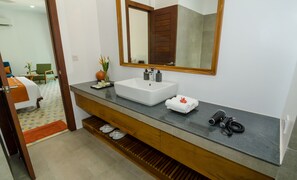 A modern bathroom with a large mirror, white sink, and wooden vanity. - Draco Residence (Siem Reap)