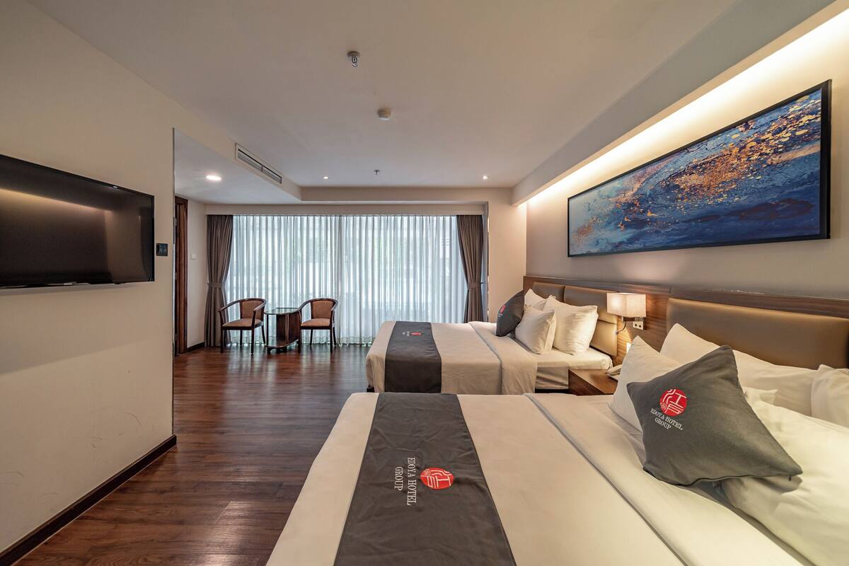 Ein Hotelzimmer mit einem großen Bett, einem Schreibtisch, einem Stuhl und einem Fernseher.