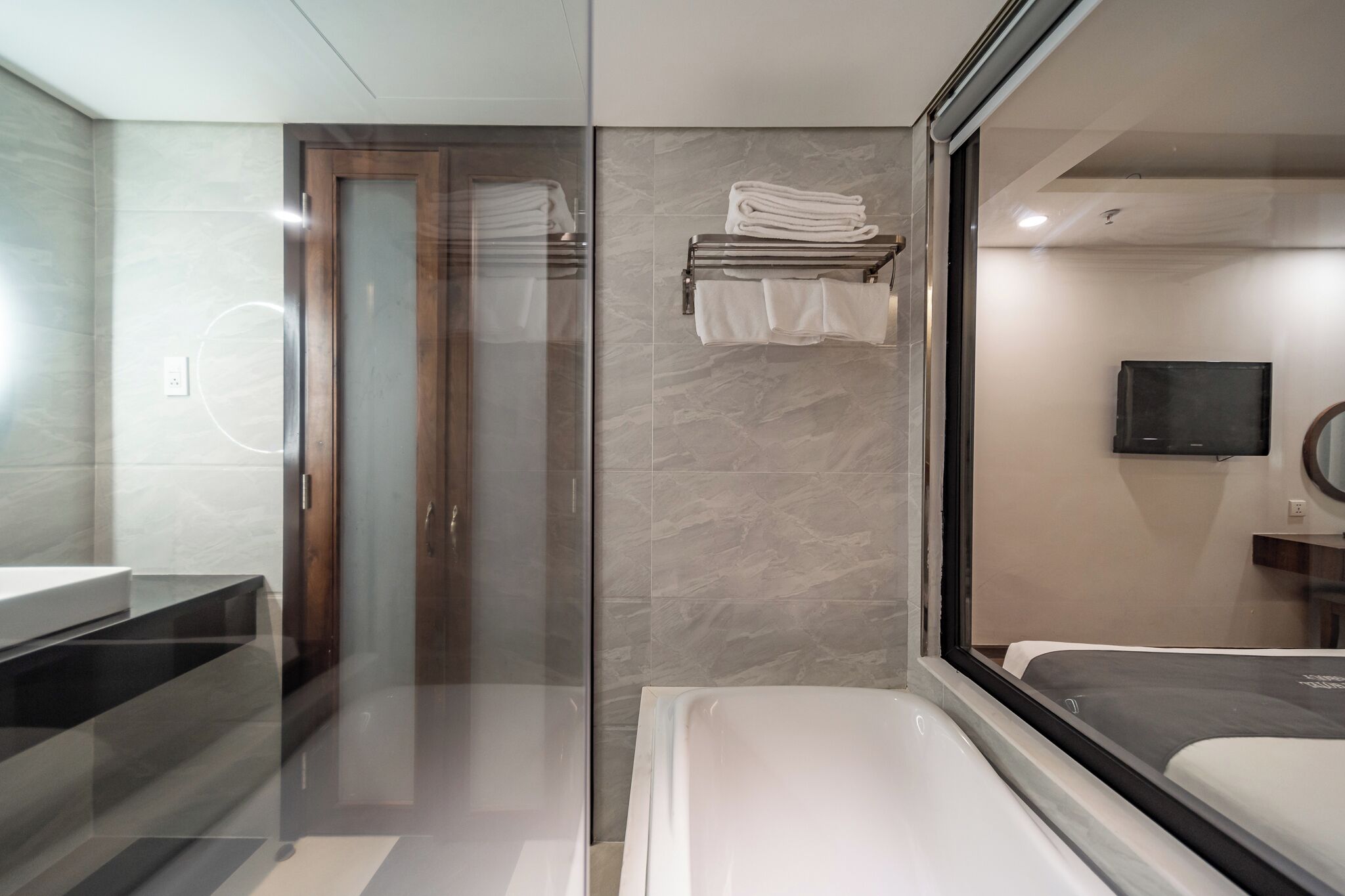 A modern bathroom with a glass shower enclosure, a built-in sink, and a large mirror.