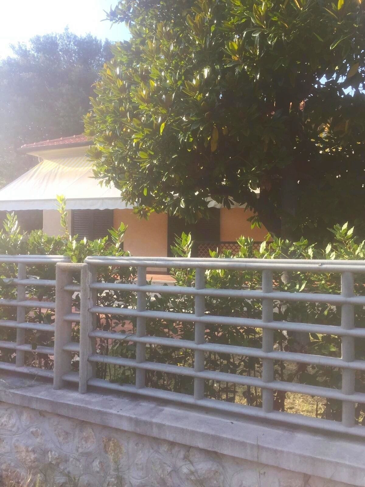 Una valla metálica con un edificio al fondo.