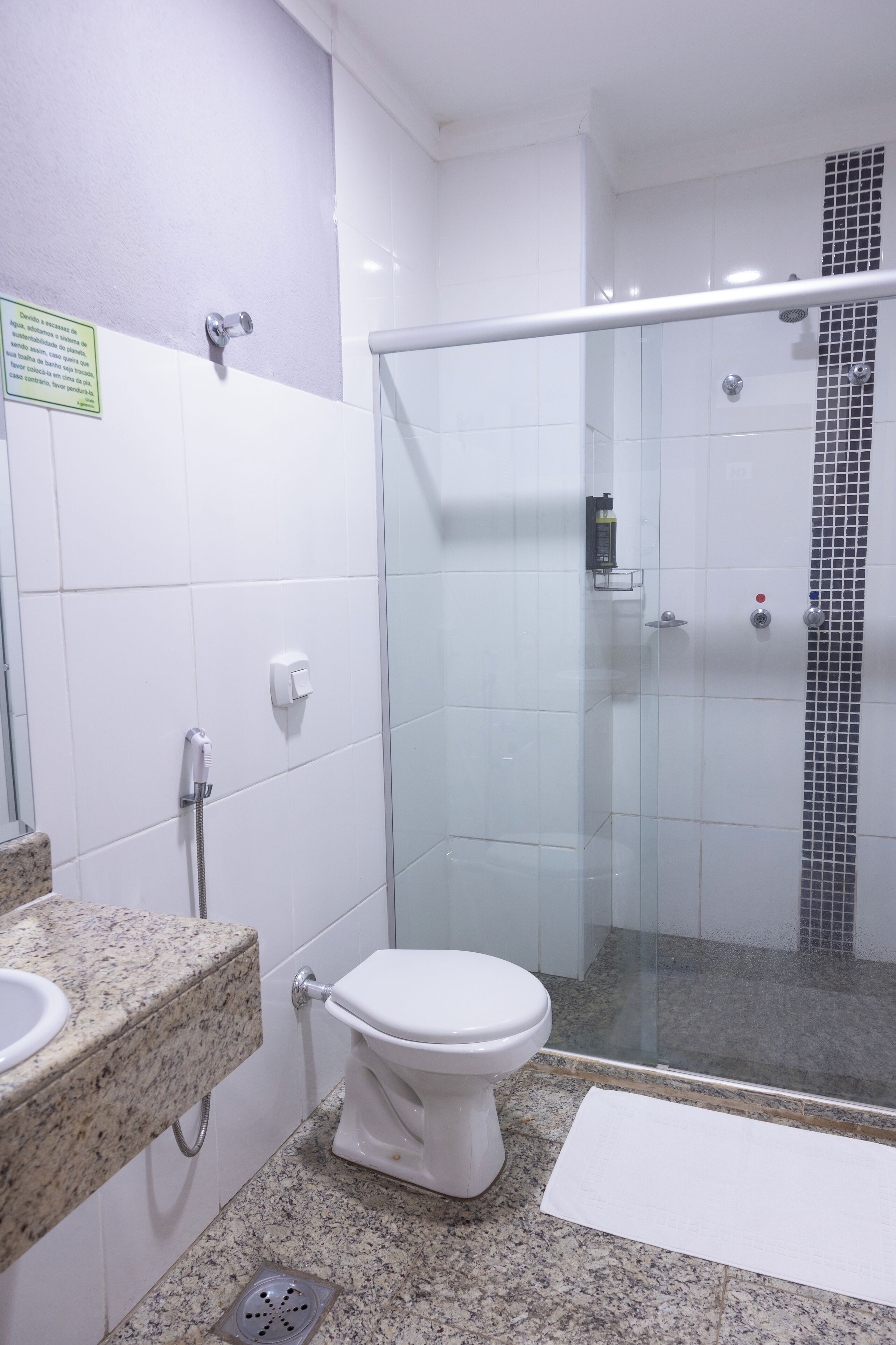 A bathroom with a toilet, sink, and shower.