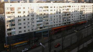 Un edificio de varios pisos con fachada plana, varios balcones y una entrada a nivel de calle con fachada de vidrio.