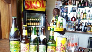 A bar counter with various bottles of beer and a refrigerator labeled 'SKOL'. - Peace & Grace Motel (Kigali)