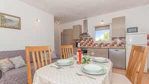 A compact living space with a dining area, kitchenette, and a sofa. - Gorgeous home in Bilice (Bilice)
