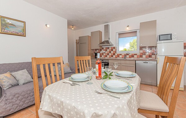 A compact living space with a dining area, kitchenette, and a sofa. - Gorgeous home in Bilice (Bilice)