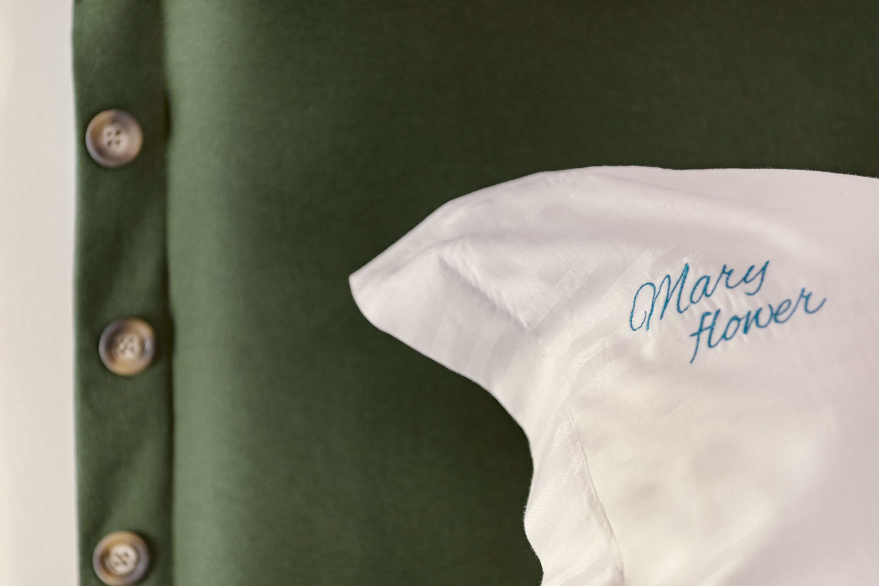 A pillow with the text "Mary Flower" embroidered on it.