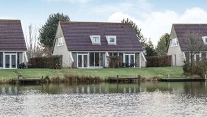 Eine Reihe von Häusern mit einem Teich im Vordergrund.