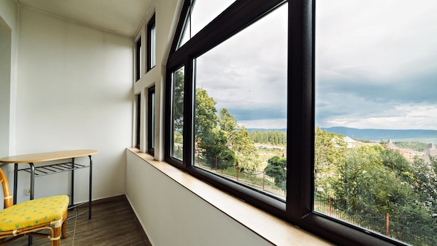 A balcony with a view of a park and distant buildings. - Apartamenty EverySky Luxor Karkonoska (Karpacz)