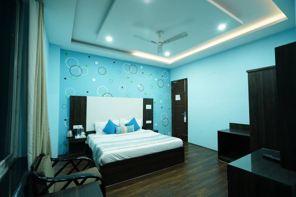 A modern bedroom with a bed, bedside tables, a desk, and a wardrobe.