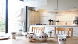 Una cocina moderna con armarios blancos, una estufa a gas y una cafetera.