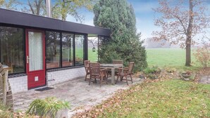 Una casa moderna con un patio, una mesa de comedor y sillas.
