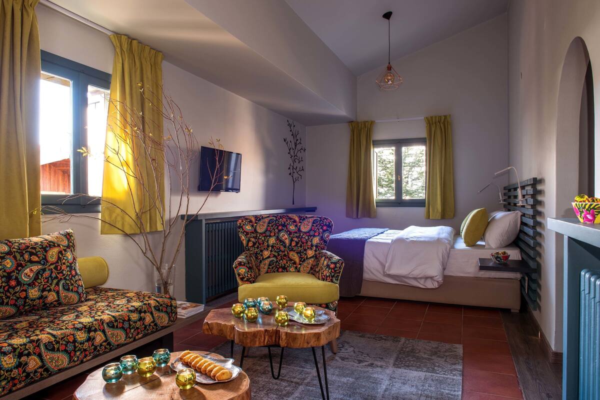 Een gezellige woonkamer met een bank, fauteuil en een klein bijzettafeltje met decoratieve objecten.