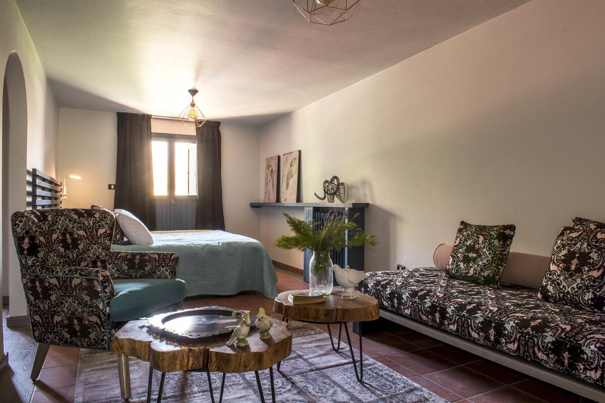 Een gezellige woonkamer met een bank, fauteuil en salontafel met decoratieve objecten.
