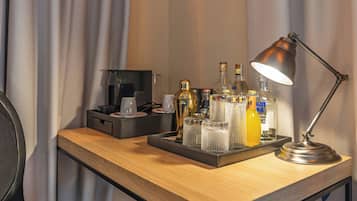 A desk with a tray holding various bottles, glasses, and a lamp.