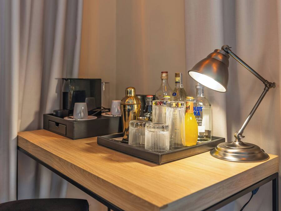A desk with a tray holding various bottles, glasses, and a lamp.